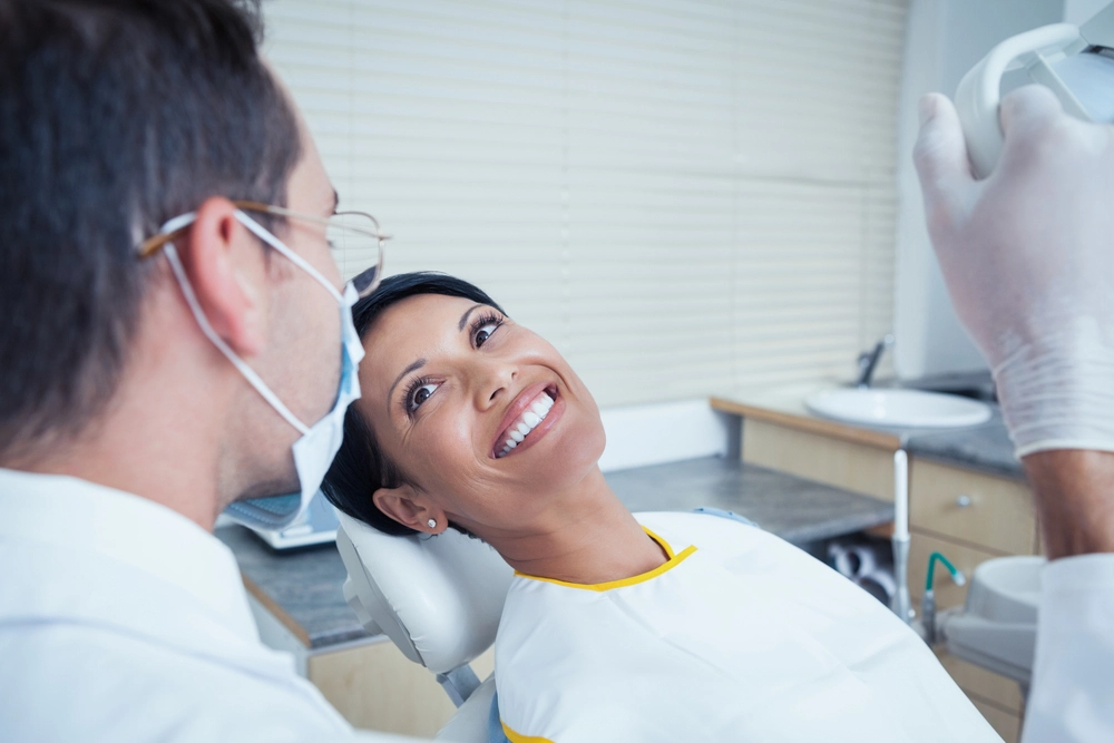 woman in dentist chair smiling at dentist